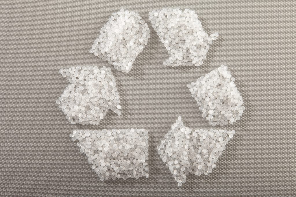 Kunststoffgranulat in Form des Recycling-Symbols